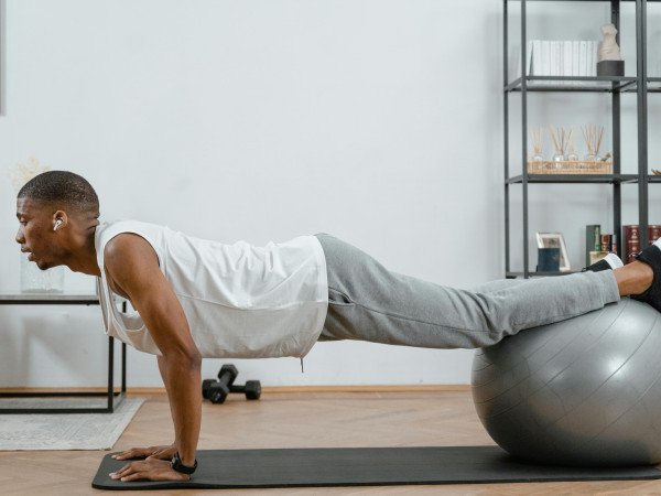 Un homme qui pratique le Pilates pour homme avec une Swissball